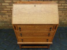 An oak slope fronted bureau with pigeon hole interior,