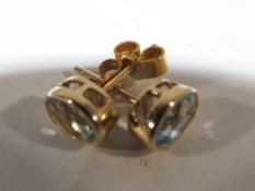 A pair of 9 carat gold and topaz solitai