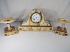 A marble Art Deco style mantel clock with garniture, marked to the dial Henri Godchot,