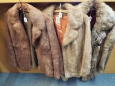 A fur coat and two fur jackets, the coat with a three button front,