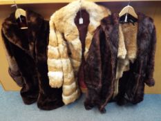 Three fur coats one in dark brown with slip pockets, approximate length 105 cm,