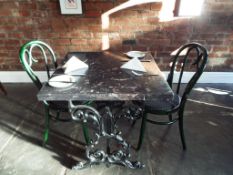 A faux marble table with cast iron legs,