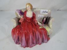 A Royal Doulton figurine depicting a seated lady, marked to the base Sweet and Twenty,