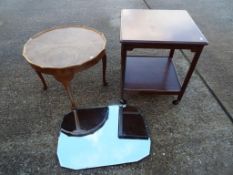 A walnut veneer coffee table, a 1920's wall mirror and a two tier side trolley.