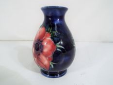 Moorcroft Pottery - a small baluster vase by Moorcroft Pottery in the Anemone pattern on a blue