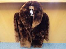 A good quality fur coat with side pockets, approximately 95 cm length.