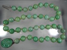 A jade bead knotted necklace with a pair of jade earrings,