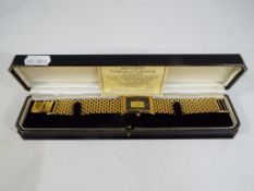 A Brooks and Bentley 18 carat gold plated wristwatch set with a one gram 24 carat gold ingot to the