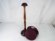 A good quality wooden wig stand and purple Fez Est £30 - £50