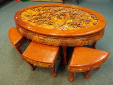 A traditional hand carved Chinese oval table set with six pull out stools