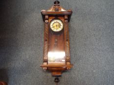 A Vienna-styled wall clock, walnut case with opening glazed door flanked by geometric decoration,