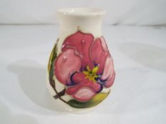 Moorcroft Pottery - a small Moorcroft Pottery squat vase decorated in the Pink Magnolia pattern on