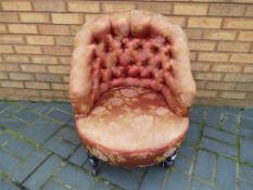 A Victorian upholstered tub chair on castors,