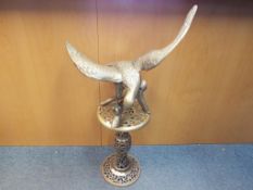 A good quality large brass sculpture depicting a bird of prey with stand,