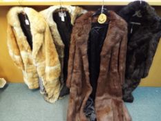 Four fur coats, one dark brown with slip pockets approximate length 125 cm,