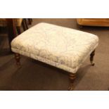 Upholstered footstool on turned wood legs