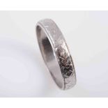 A PLATINUM RING, of simple form with engraved detailing to the entirety. Stamped PLATINUM.