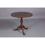 A GEORGE III OAK TILT-TOP TRIPOD TABLE, with circular top and turned stem continuing to pad feet.