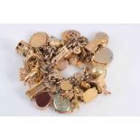 A YELLOW GOLD CHARM BRACELET, set with multi charms to include St Christopher's, lockets,