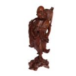 A CHINESE HARDWOOD CARVING, the figure modelled standing. 36.