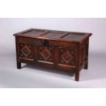 AN OAK COFFER, LATE 17TH CENTURY, with three panel lid and carved panel front.
