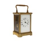 A FRENCH BRASS CASED CARRIAGE CLOCK, the white enamel dial with Roman numerals, complete with key.