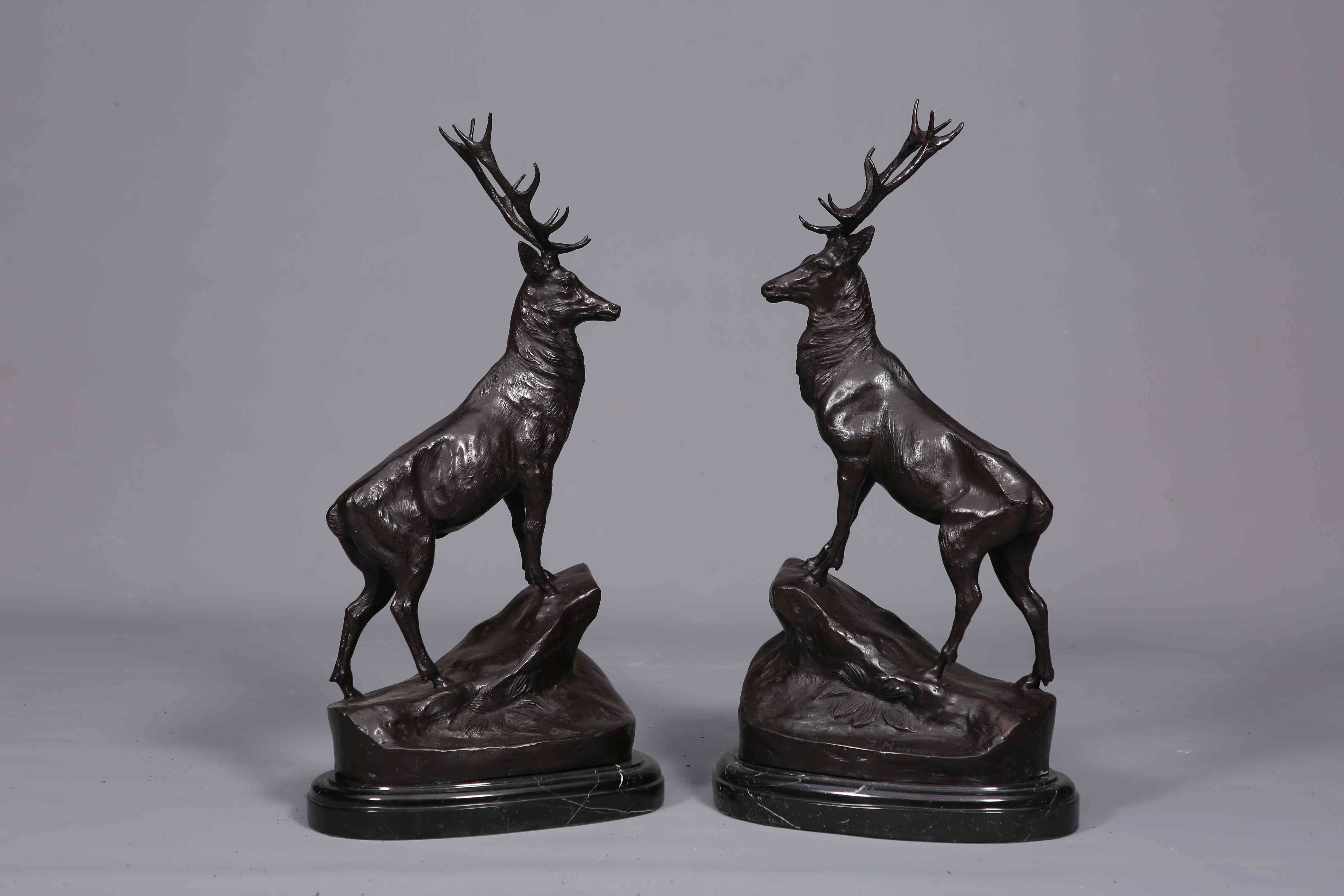 A LARGE PAIR OF BRONZE STAGS, each cast standing on a rocky outcrop. 73.