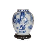 A CHINESE BLUE AND WHITE PORCELAIN VASE, decorated in the round with figures, on a wooden stand.