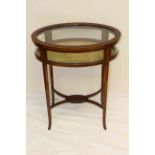 AN EDWARDIAN INLAID MAHOGANY BIJOUTERIE TABLE, oval with string inlay and square-section legs.