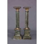 A PAIR OF GREEN MARBLE TORCHERES, each with reeded column and brass collars. 101.