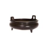 A CHINESE BRONZE CENSER, circular with twin lugs and four feet, probably 19th Century. 14.