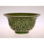 A CHINESE GREEN GLAZED BOWL, relief moulded with two dragons and flaming pearls.