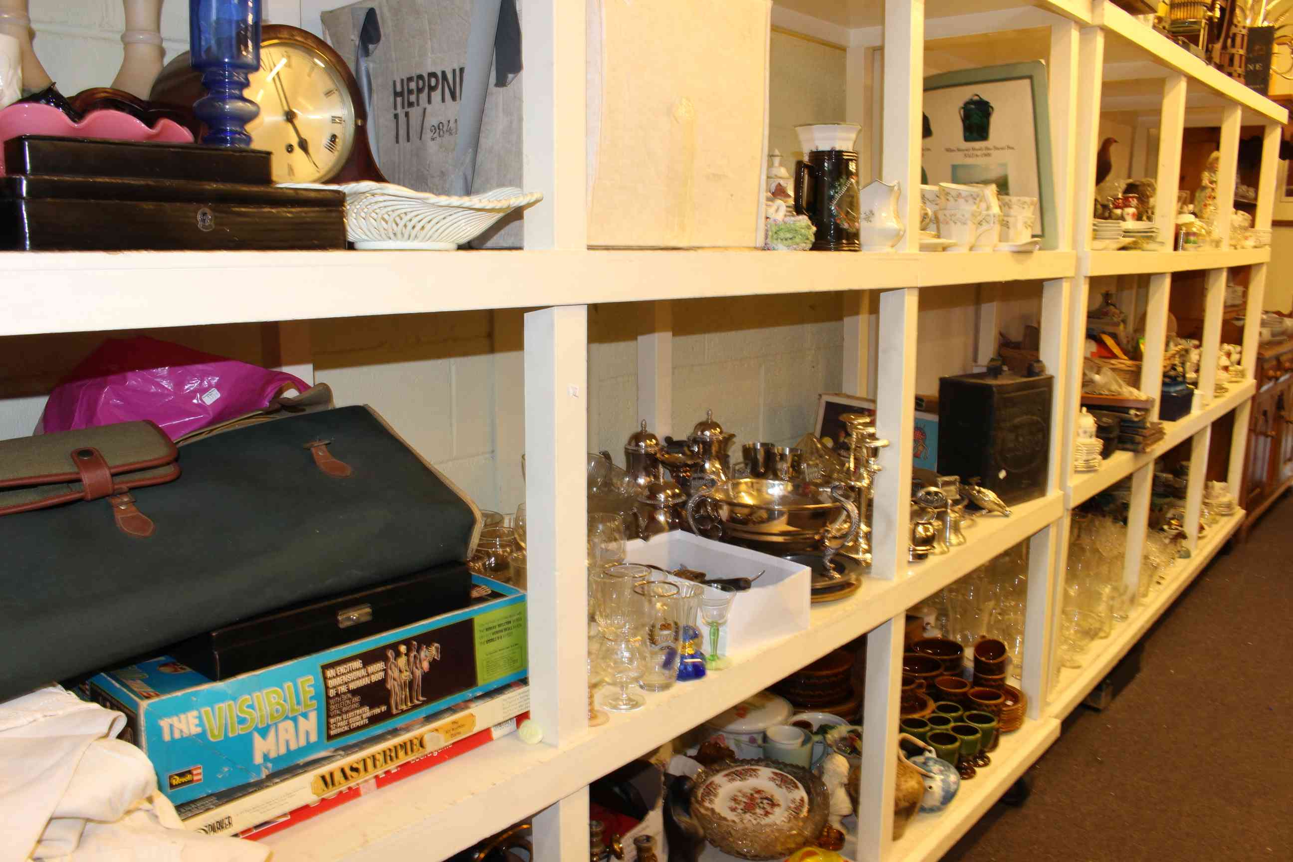 Full shelf of various teawares, games, silver plated ware, ESSO petrol can, linen, glassware,