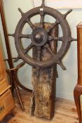 Large wood and metal ships wheel mounted on wooden beam