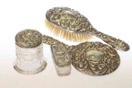 Embossed silver backed brush and mirror and two toilet jars (4)