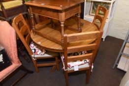 Circular oak extending dining table and four ladder back chairs