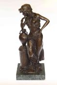 Large bronze of semi clad female resting by an urn on plinth