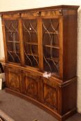 Mahogany concave fronted bookcase with three glazed doors above three cupboard doors