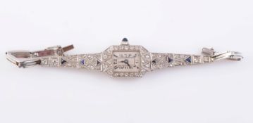 AN ART DECO PLATINUM, DIAMOND AND SAPPHIRE LADY'S COCKTAIL WATCH, the dial with Arabic numerals,