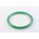 A JADEITE BANGLE, of simple polished form. Diameter 7.5cm. Weight 24.1gms.