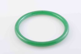 A JADEITE BANGLE, of simple polished form. Diameter 7.5cm. Weight 24.1gms.