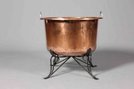 A LARGE POLISHED COPPER CHEESE KETTLE, with wrought iron stand. 67.