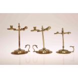 THREE GEORGE III BRASS WAX JACKS, circa 1775, each of characteristic form with urn finial,