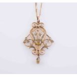 AN EDWARDIAN PERIDOT, SEED PEARL AND 15 CARAT GOLD PENDANT, in Art Nouveau style,