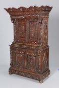 A CARVED OAK CUPBOARD, with shaped cornice above a drawer over a pair of doors,