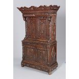 A CARVED OAK CUPBOARD, with shaped cornice above a drawer over a pair of doors,