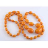 AN AMBER NECKLACE, the fifty-three graduating oval amber beads strung knotted into a single row.