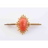 A CORAL AND YELLOW METAL CAMEO BROOCH, the oval cameo carved to depict a gentleman in profile,