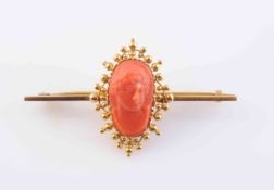 A CORAL AND YELLOW METAL CAMEO BROOCH, the oval cameo carved to depict a gentleman in profile,