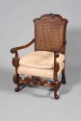 A CAROLEAN STYLE WALNUT ARMCHAIR, with double walled canework back and scroll feet.